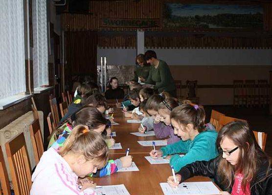 Uczniowie ze Szkoły Podstawowej w Charzykowach w czasie zajęć w sali Wiejskiego Domu Kultury w Swornegaciach grafika