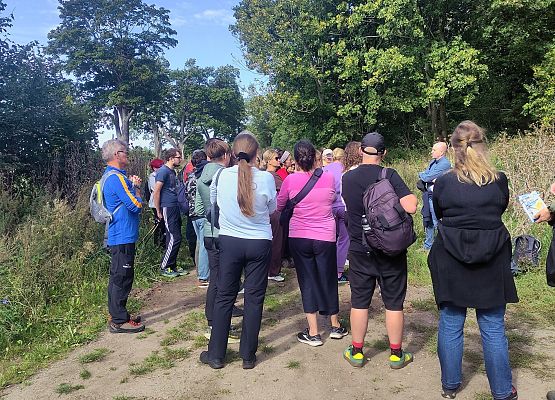 Przestrzeń, która łączy – spacer przez historię i krajobraz Grupa uczestników spaceru na leśnej drodze.