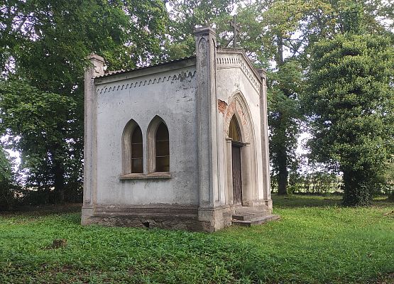 Przestrzeń, która łączy – spacer przez historię i krajobraz Neogotycka kaplica grobowa, biała elewacja, strzeliste okna. W tle drzewa.