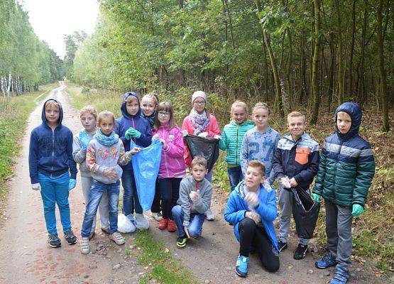 Uczniowie Szkoły Podstawowej w Kłodawie podczas sprzątania lasu.
