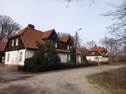 Na zdjęciu zabytkowa zabudowa wyłuszczarni nasion w Klosnowie. Budynek o białej elewacji, kryty dachówką.